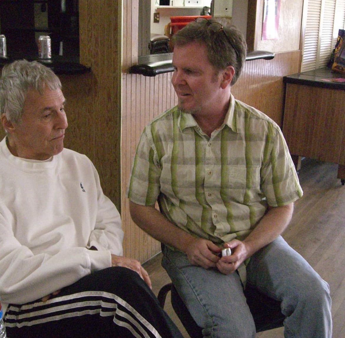 Burt Bacharach, on the left, and Steve Gunderson seated in conversation in a wood-panelled room.
